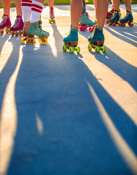 Legs of women in roller skates on sidewalk