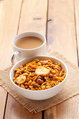 Close-Up of crunchy Indian Navratan mixture snacks with hot tea or Coffee. Studio shoot at a declined angle. 