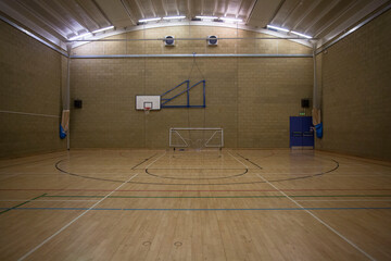 Sports gymnasium with basketball hoop and football net