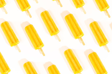 Mango orange ice lollies patterned summer flat lay concept on light white background