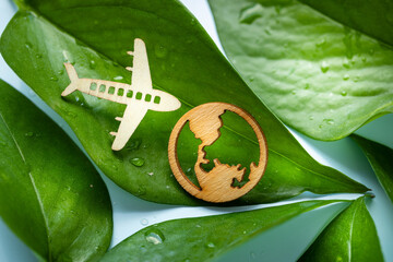 symbol of modern air transport, Electric airplane, airplane and earth icon on green leaves...