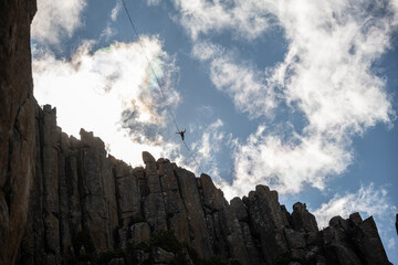 Fototapeta premium Person on a slackline/highline in the mountains