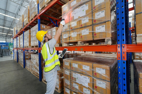 Warehouse Industrial supply chain and Logistics Companies inside. Warehouse workers checking the inventory. Products on inventory shelves storage. Worker Doing Inventory in Warehouse.