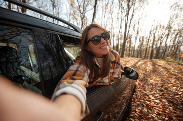 Pov of the woman making selfie from the car window during the autumn road trip