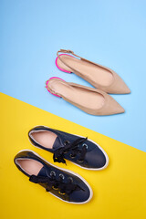 Two pairs of women's shoes of different colors and styles on a geometrical two-colored background. Top view, flat lay. Lifestyle, the concept of choosing shoes.
