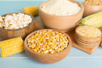 Maize products with fresh corn cobs on wooden table