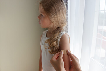 Arm with a plaster on the skin. Concept of vaccination and immunization, soft focus background