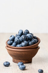 Ripe blueberries in a bowl on the table, healthy and tasty berry