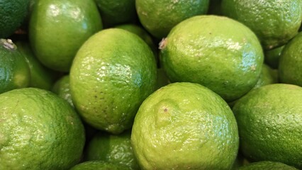 Green lemons on the counter in the market in a drawer