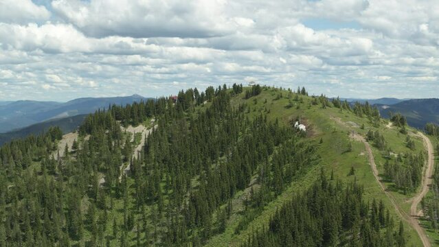 Wide aerial of fire tower on northern Idaho mountain top near Kellogg
