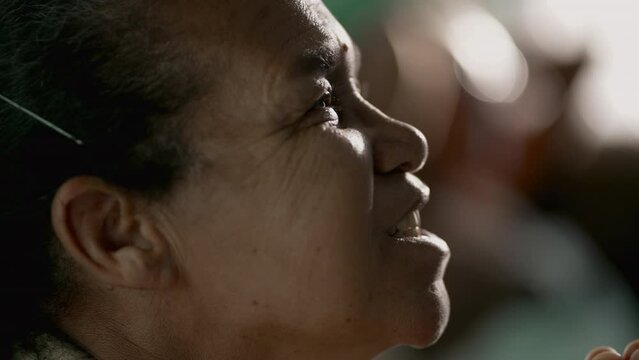 Happy senior woman looking at sky with HOPE profile closeup face. Older mature South American Brazilian lady having FAITH