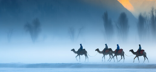 Fototapeta na wymiar little caravan riding by desert. Silhouette of tourists on camel ride convoy. Autumn scenery of Crescent Moon Lake, digital ai