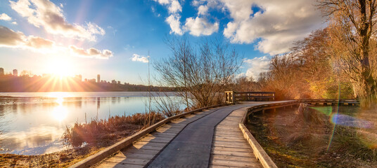 Wooden pathway in a city park by the lake. Sunset. Deer Lake, Burnaby, Vancouver, BC, Canada
