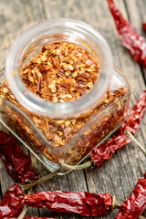 Crushed and whole chili peppers in jar.