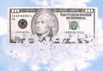 A ten dollar bill crumbles into small fragments at the bottom. Visual representation of inflation....
