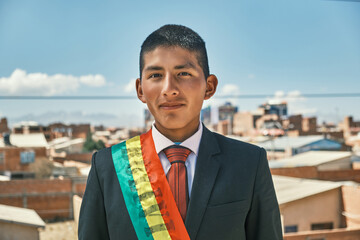 young latin bolivian flag bearer with the bolivian flag in black suit