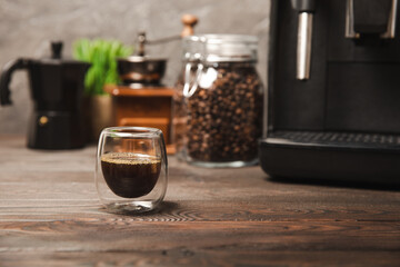 Modern coffee machine with a cup on the kitchen table. Coffee house. Modern espresso coffee machine with a cup in the kitchen. Preparation of a fragrant hot drink. Place for text.Copy space.