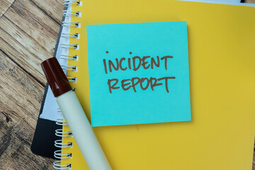 Concept of Incident Report write on sticky notes isolated on Wooden Table.