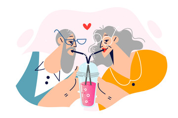 Elderly romantic couple drinks cocktail from straws in one glass, showing love and affection