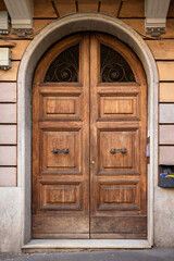 Rounded double dark old European wood doors of an apartment, building or home in Rome Italy