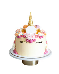Bright and colorful unicorn cake with golden horn, meringue swirls and copy space on fondant plate