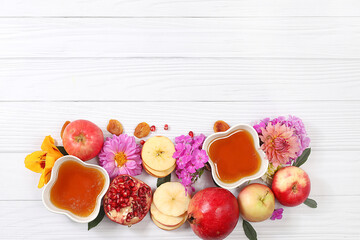 Autumn banner with honey, apples, pomegranates, flowers, dried fruits on light background with...