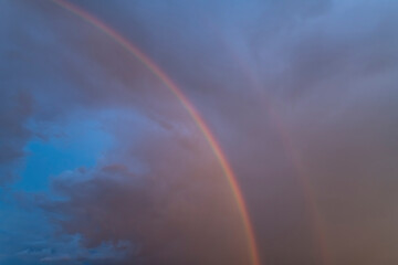 Rainbow in the rain against a beautiful sky