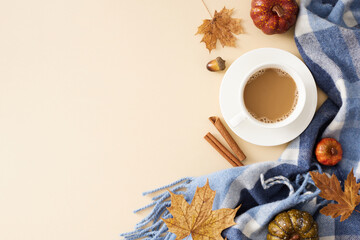 Cozy up to fall at home. Top view photo of coffee mug, warm blanket, cinnamon sticks, pumpkins, acorns, dry maple leaves on pastel beige background with empty space for promo or text