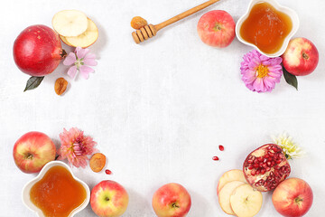 Apples, honey,pomegranate and dried apricots on a bright white background,The concept of the Jewish holiday Rosh Hashanah top view with a place for your text,Jewish New Year and Thanksgiving,