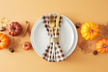 Autumnal festive table arrangement. Top view composition plate, cutlery, checkered napkin,...
