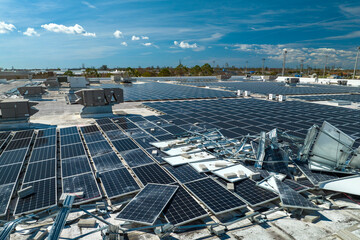 Aerial view of damaged by hurricane wind photovoltaic solar panels mounted on industrial building...