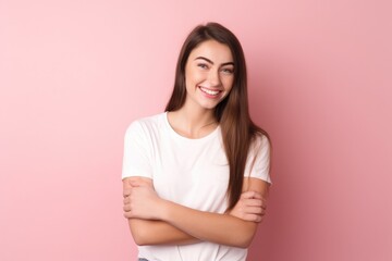 Fototapeta premium Young beautiful girl in a white T-shirt on a pink background