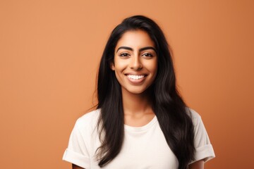Obraz premium Young beautiful girl in a white T-shirt on a orange background