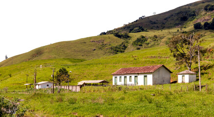 Fototapeta na wymiar Old colonial farmhouse, with corral. Hill with pasture for cows and small stream. Countryside of Rio de Janeiro