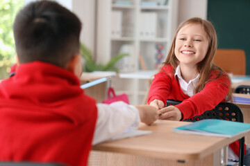 Obraz premium Little girl with her classmate at school