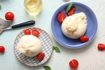 Plates with tasty Burrata cheese on blue background