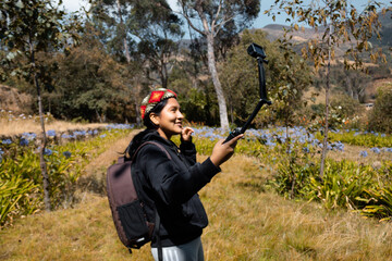 Mujer joven tomando selfie a través de smart gopro durante la naturaleza de verano