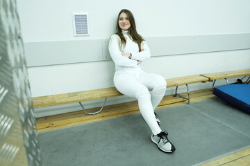 Professional fencer girl with fencing mask and rapier. Training in hall 