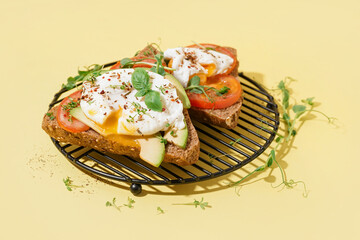 Grid of tasty sandwiches with egg on yellow background