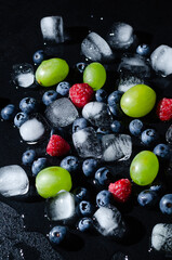 berries with ice cubes on a black background
