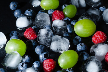 berries with ice cubes on a black background