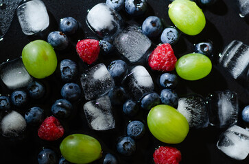 berries with ice cubes on a black background