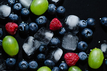 berries with ice cubes on a black background