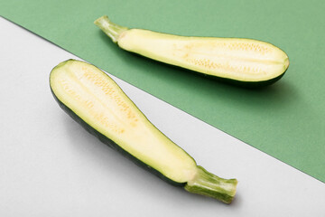 Halves of fresh green zucchini on colorful background