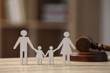 Family law. Figure of parents with children and gavel on wooden table, space for text