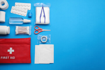Flat lay composition with first aid kit on light blue background. Space for text