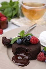 Delicious chocolate fondant served with fresh berries on table, closeup. Space for text