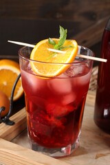 Glass of delicious refreshing sangria on wooden tray, closeup