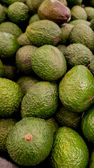 Fresh green avocados filling the frame, food or produce background.