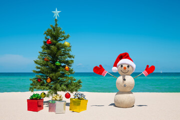Christmas Tree and Snowman. Sandy snowman on the beach. Merry Christmas. Happy New Year. Smiling...